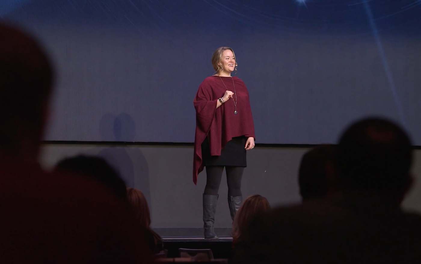 Meghan speaking on a conference stage