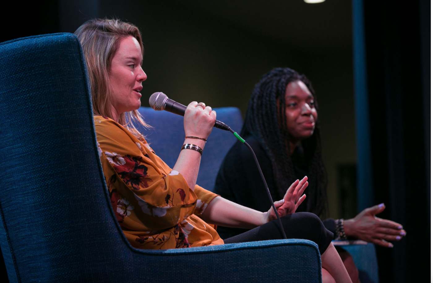 Meghan interviewing a guest on stage