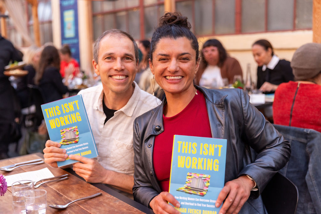 Two readers holding up their copies of This Isn't Working