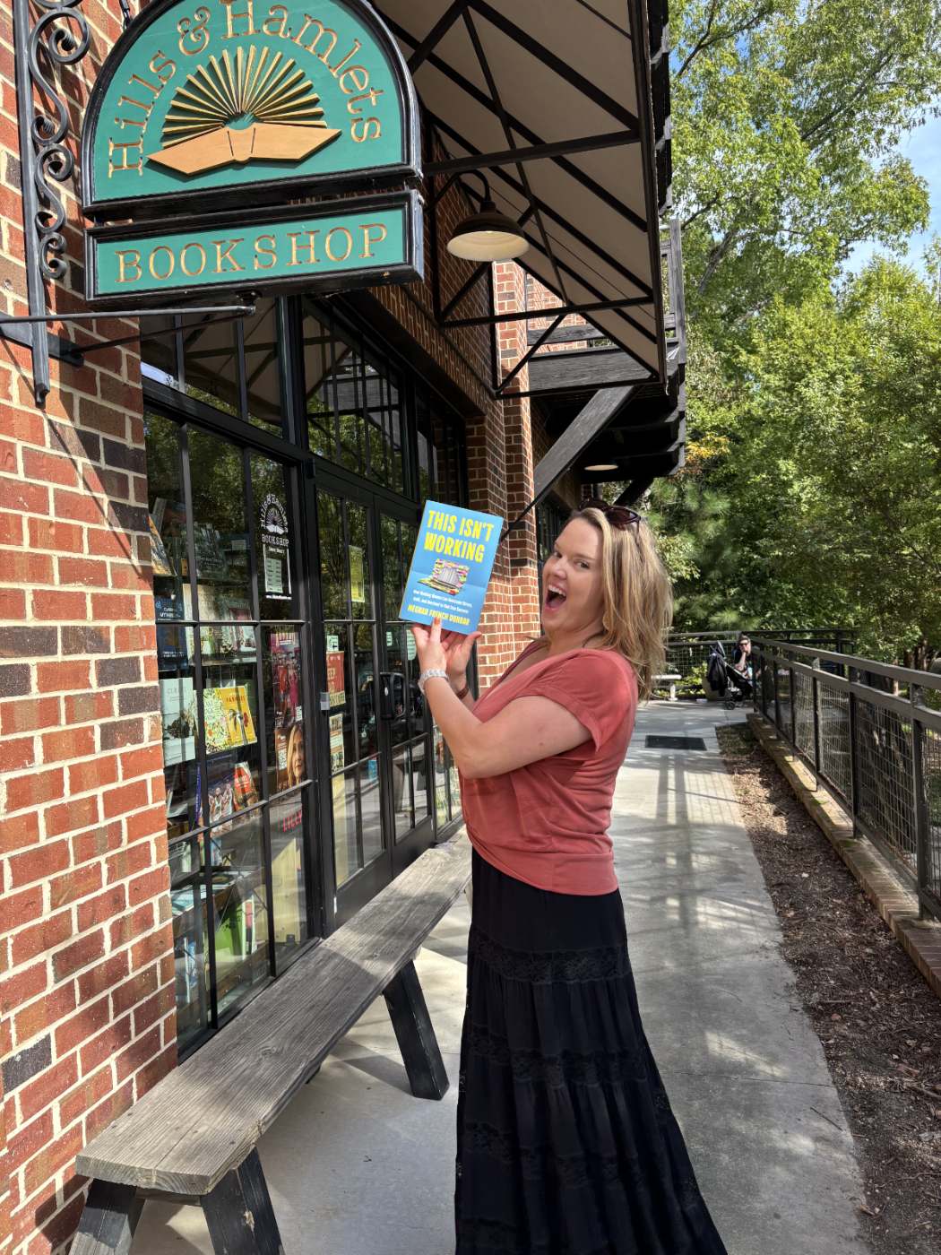 Meghan holding up This Isn't Working outside Hills & Hamlets Bookshop